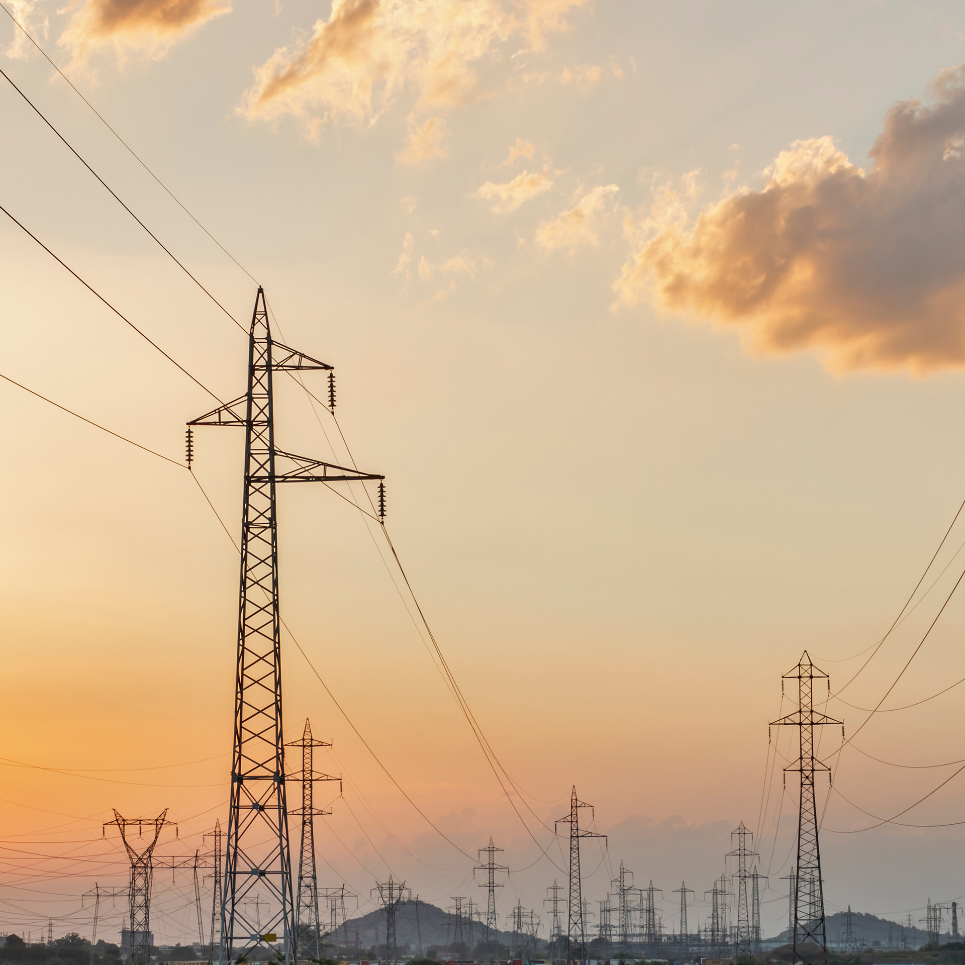 Power lines against an orange and grey twilight sky