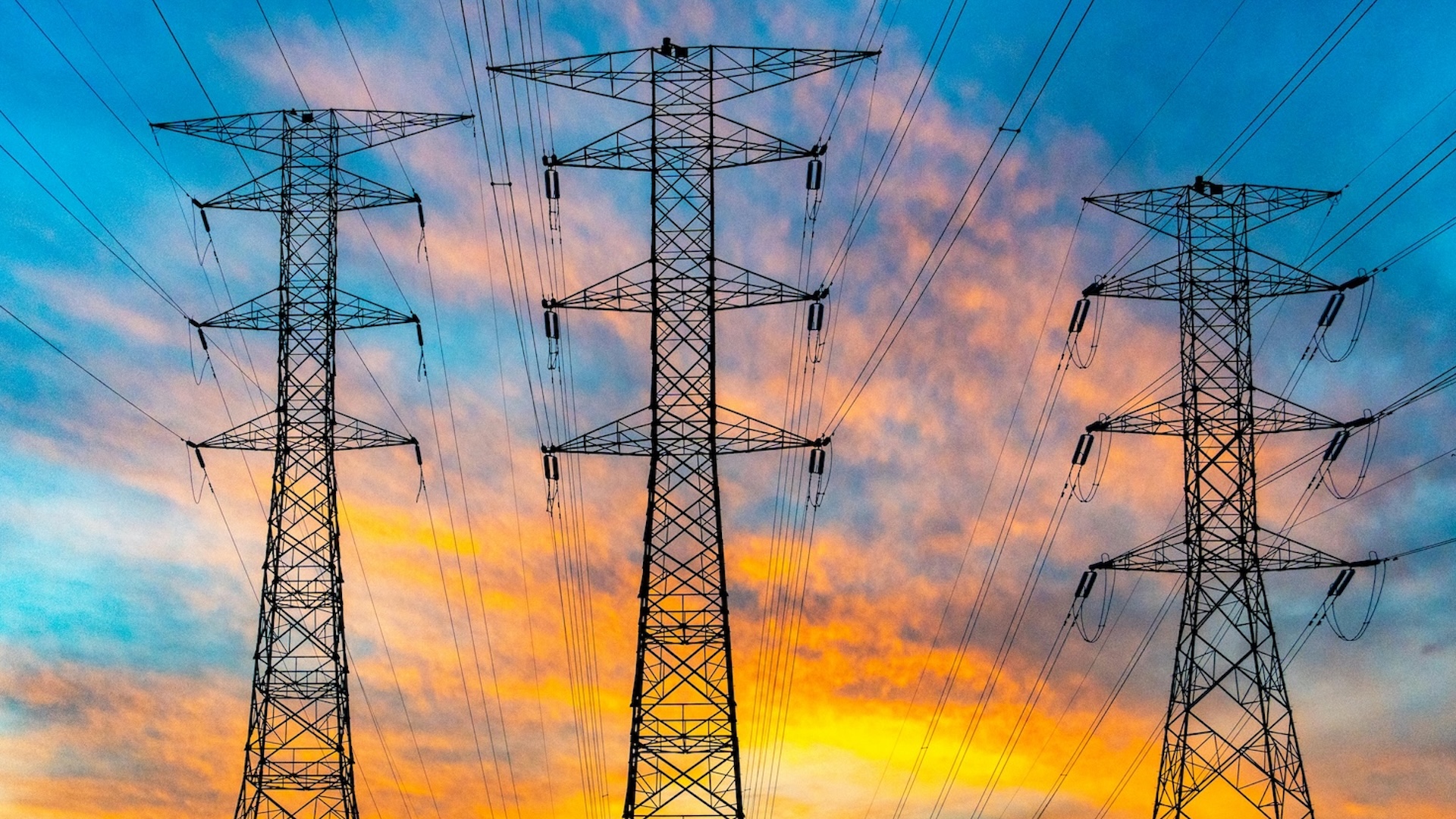 transmission towers with a colorful sky